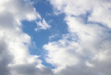 Bright March blue sky with white and gray clouds in sun light