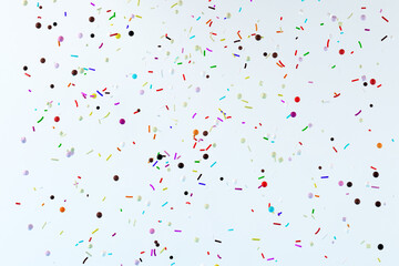 Abstract flying colorful pastry sprinkles on white background. 3d render illustration.