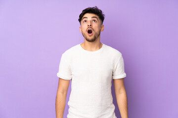 Arabian handsome man over isolated background looking up and with surprised expression
