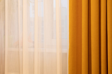 Dark yellow and white curtains against window in a sunny day