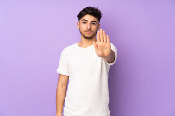 Arabian handsome man over isolated background making stop gesture