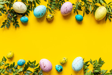Happy Easter with colorful eggs and green branch, top view