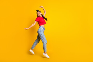 Fototapeta na wymiar Full length body size profile side view of pretty cheerful girl jumping having fun dancing isolated bright yellow color background