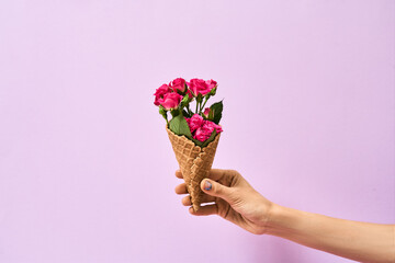 Bouquet in the hands of a girl on pink background