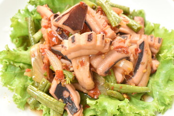 spicy stir fried squid with yard long bean  and fresh vegetable on plate