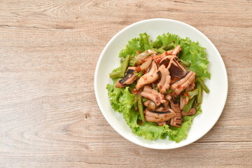spicy stir fried squid with yard long bean  and fresh vegetable on plate
