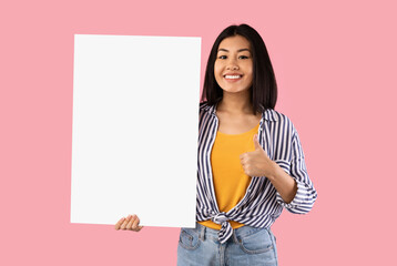 Fototapeta na wymiar Asian woman holding blank white advertising billboard showing thumbs up