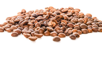 Coffee beans lie on the table on a white background.