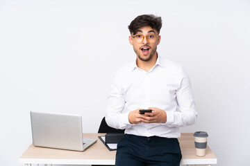 Arabian man in a office isolated on white background surprised and sending a message