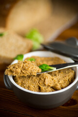 homemade meat pate in a ceramic bowl on a wooden table