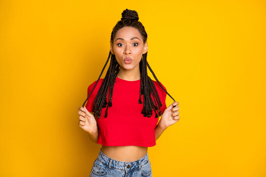 Portrait of pretty amazed cheerful girl having fun touching hairdo pout lips isolated over bright yellow color background