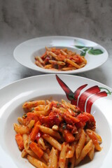 white plate with round ravioli and lots of different vegetables, thinly sliced vegetables and Italian dumplings, egg pasta ravioli, Italian dumplings sprinkled with cheese, mix of vegetables