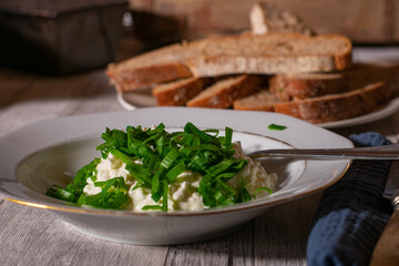 A plate with cottage cheese with chives and bread