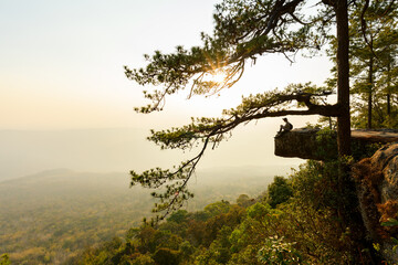Man traveler on cliff with beautiful landscape sunset in national park, Thailand.