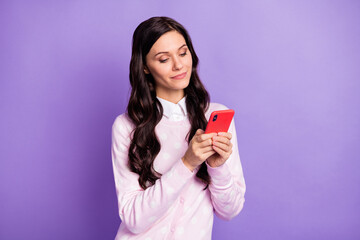 Portrait of lovely cheery wavy-haired girl holding in hand using device app 5g like isolated on violet color background