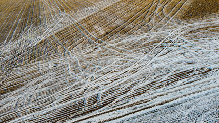 Fields covered in snow and tracks.