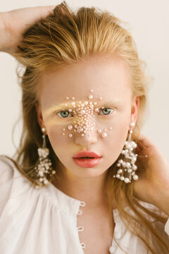 Portrait of a beautiful girl with pearls on her face