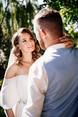 groom in blue suit and bride with curls of stand in willow