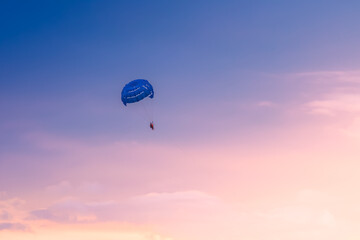 Parasailing on sunset and blue sky background in tropical country