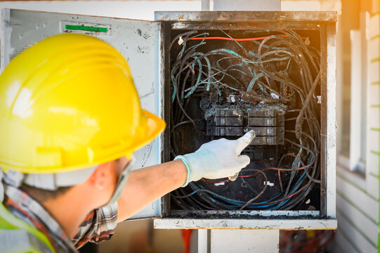 Electrician checking an control panel after an electrical fire, Thailand