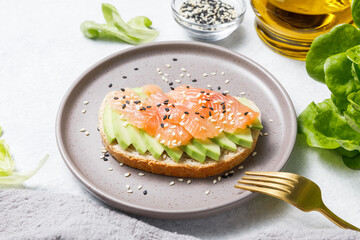 Avocado toast with salmon on white stone table background. Close up