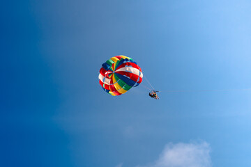 Parasailing in blue sky. Sports, active leisure, travel, vacation concept