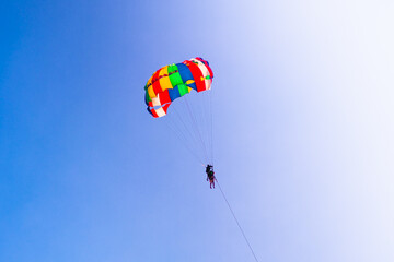 Parasailing in blue sky. Sports, active leisure, travel, vacation concept