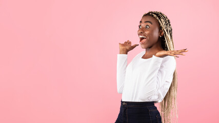 Portrait of amazed young black woman looking at copy space