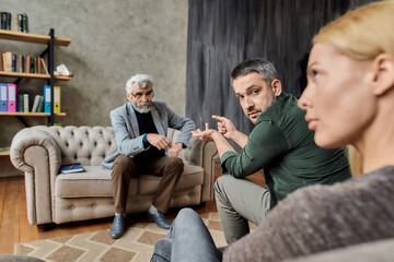 Angry young caucasian spouses with professional psychotherapist