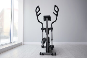 Elliptical machine cross trainer near window indoors