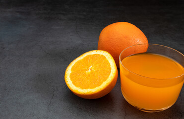 Fresh orange juice on dark stone table
