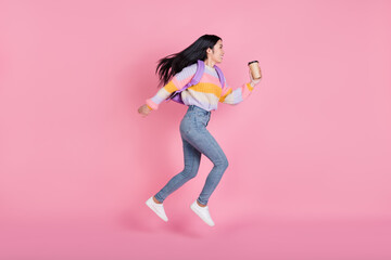 Full size profile side photo of young happy smiling girl running with backpack drink coffee...