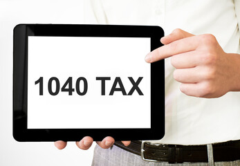 Fototapeta na wymiar Text 1040 TAX on tablet display in businessman hands on the white bakcground. Business concept