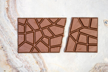 Sweet and delicious whole chocolate bar lies on light stone background photo taken from above in...
