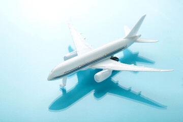 Model airplane with shadow on blue pastel color background.