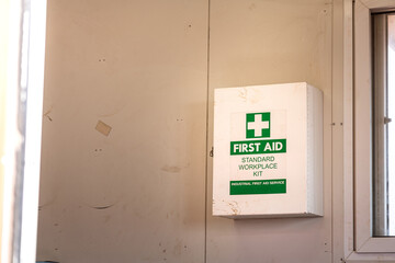 An industrial use standard "First Aid" box which is installed on medical support room container's wall. Healtcare and medical equipment object.