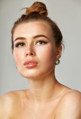 Beautiful face of young adult woman with clean fresh skin - isolated on gray