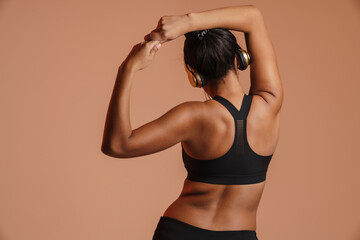 Obraz premium African american woman in headphones doing exercise while working out