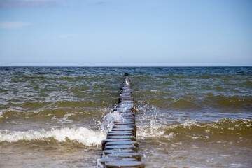 Breaking waves on the wooden planks at the Baltic Sea..
