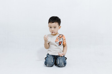 boy eats lollipops on white background