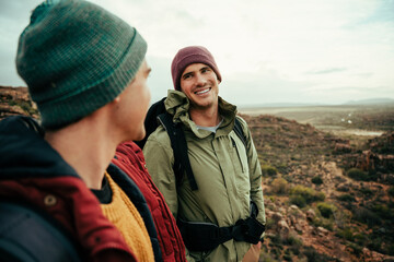 Group of caucasian friends smiling walking through forest terrain enjoying the fresh air 