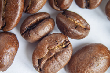 Freshly roasted coffee beans on a white background. Close-up. Selective focus