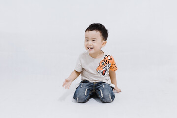 boy eats lollipops on white background