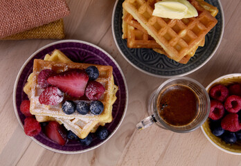 Homemade traditional belgian waffles with fresh fruits berries top view stock images. Fresh waffles with berries on the table photo. Sweet breakfast with waffles, fruit and cup of coffee images