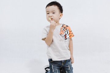 boy eats lollipops on white background