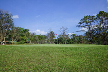 Obraz premium Background of evening golf course has sunlight shining down at golf course in Thailand. Nice scenery on a golf course at a late summer afternoon.