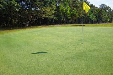 Obraz premium Background of evening golf course has sunlight shining down at golf course in Thailand. Nice scenery on a golf course at a late summer afternoon.