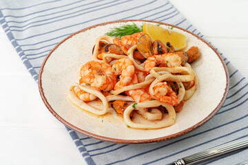 Stir fried seafood with sauce on plate with napkin