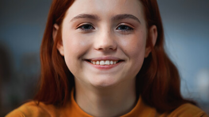 Portrait of red haired teenager smiling at camera