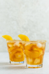 Tropical orange iced tea, summer party drink in glasses. Space for text.